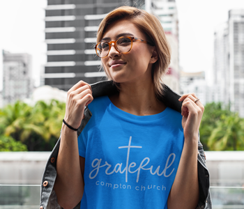 woman wearing blue t shirt with grateful compton church design on it
